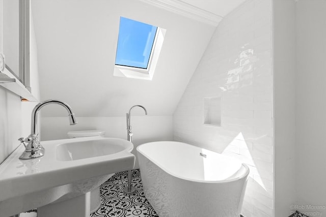 91 Bartholomew St, Peabody, MA 01960 - bathroom featuring a skylight, a freestanding tub, vaulted ceiling, crown molding, and tile patterned flooring