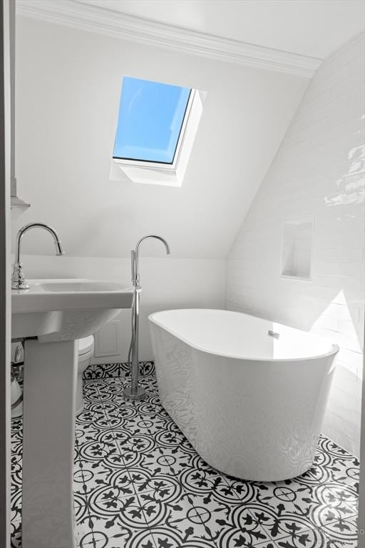 91 Bartholomew St, Peabody, MA 01960 - bathroom featuring a skylight, a freestanding bath, crown molding, and tile patterned flooring