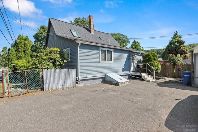 91 Bartholomew St, Peabody, MA 01960 - rear view of house with a shingled roof and a chimney