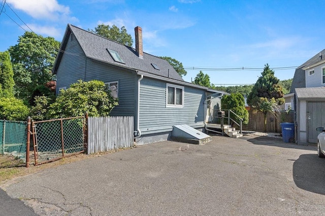 91 Bartholomew St, Peabody, MA 01960 - view of side of home with a shingled roof and a chimney