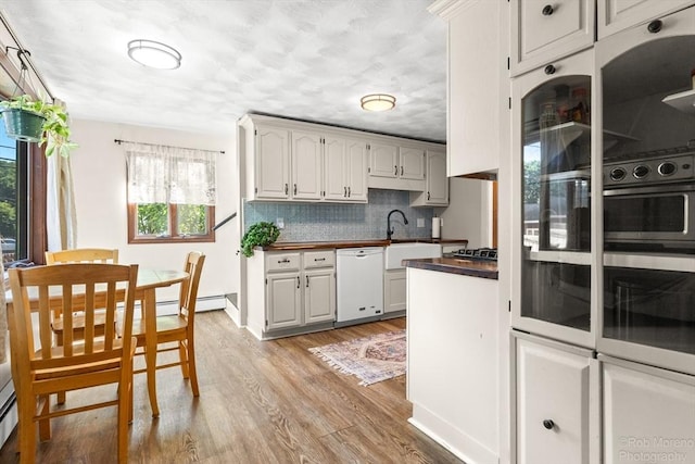 91 Bartholomew St, Peabody, MA 01960 - kitchen with dishwasher, light wood-style floors, tasteful backsplash, wood counters, and multiple ovens