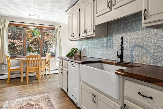 91 Bartholomew St, Peabody, MA 01960 - kitchen featuring white dishwasher, dark countertops, backsplash, light wood-style flooring, and a baseboard heating unit