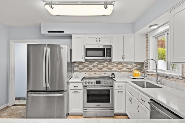 kitchen featuring appliances with stainless steel finishes, a sink, backsplash, and white cabinets