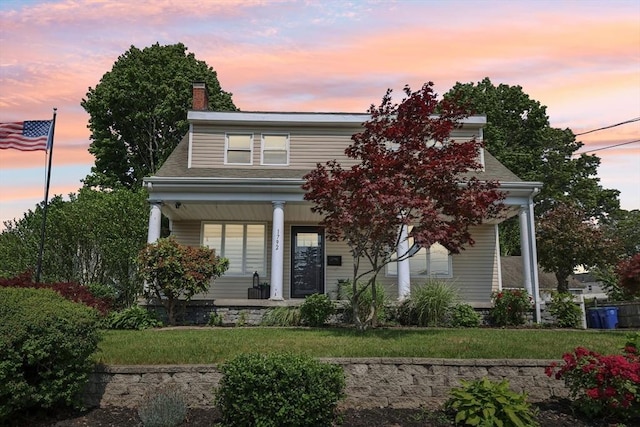 1792 Washington St, Braintree, MA 02184 - view of front of home featuring a porch, a lawn, and a chimney