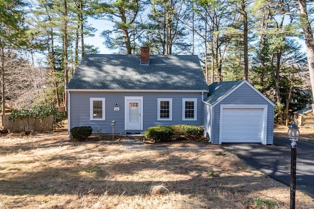 cape cod home with aphalt driveway, roof with shingles, a chimney, and fence