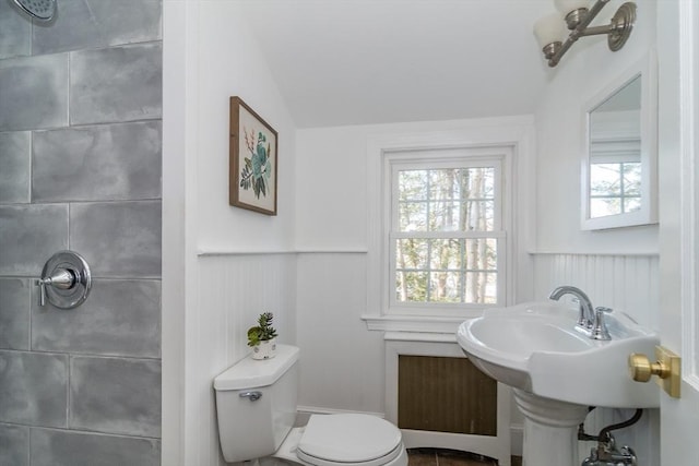 bathroom featuring toilet and a wainscoted wall