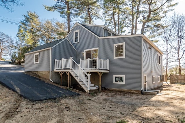 rear view of house with stairs and a deck