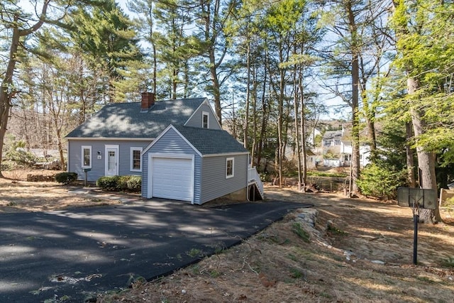 exterior space featuring aphalt driveway and a chimney