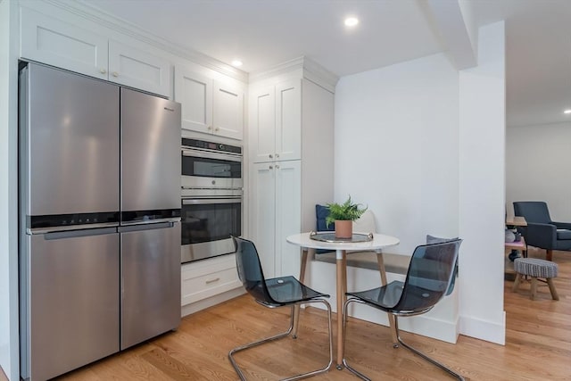 kitchen with light wood-style flooring, recessed lighting, white cabinets, and stainless steel appliances