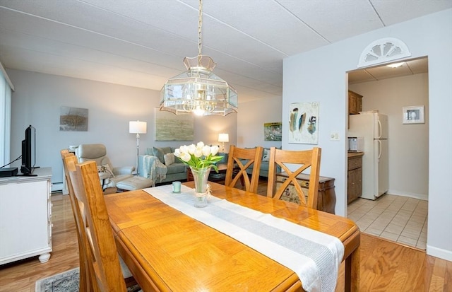 dining space featuring baseboards and light wood-style floors