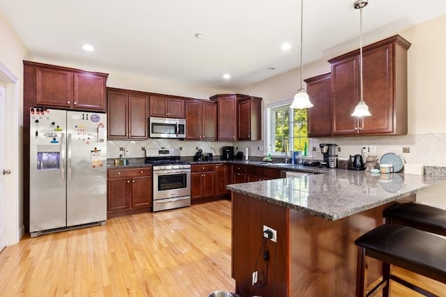 6 Comanche Ter Unit 6, Westford, MA 01886 - kitchen with appliances with stainless steel finishes, a peninsula, hanging light fixtures, light wood-type flooring, and dark stone countertops