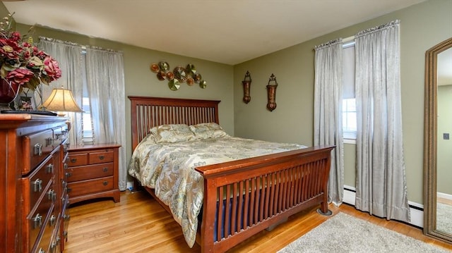 bedroom featuring light hardwood / wood-style flooring and baseboard heating