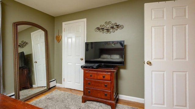 bedroom featuring a baseboard radiator and light hardwood / wood-style floors