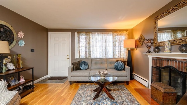 living room with a fireplace, a baseboard radiator, and light wood-type flooring