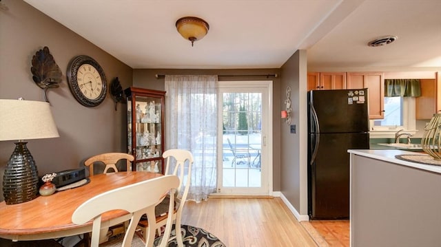 dining space with sink and light hardwood / wood-style floors