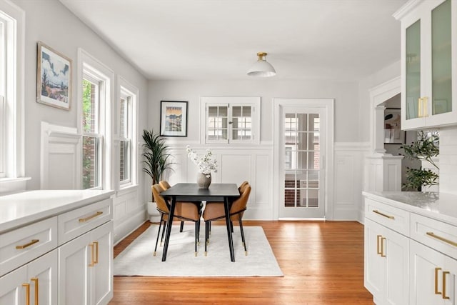 301 Pond St, Boston, MA 02130 - dining area featuring light wood-style flooring, a wainscoted wall, and a decorative wall