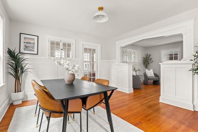 301 Pond St, Boston, MA 02130 - dining space with a decorative wall, a wainscoted wall, and light wood-style flooring