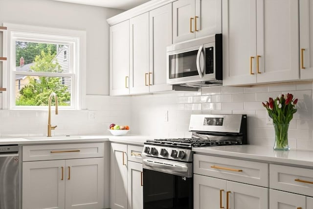 301 Pond St, Boston, MA 02130 - kitchen featuring appliances with stainless steel finishes, a sink, decorative backsplash, and light countertops