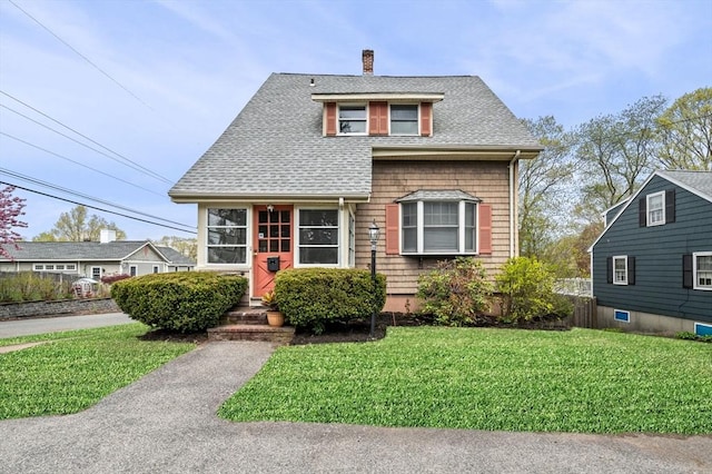 bungalow-style house featuring a shingled roof, a chimney, and a front yard