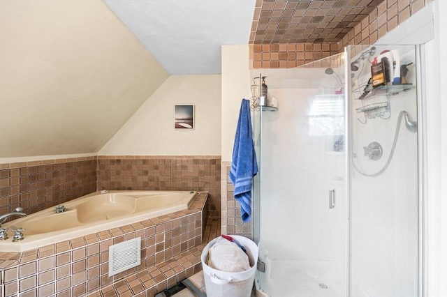 bathroom featuring a stall shower, lofted ceiling, tile walls, and a bath