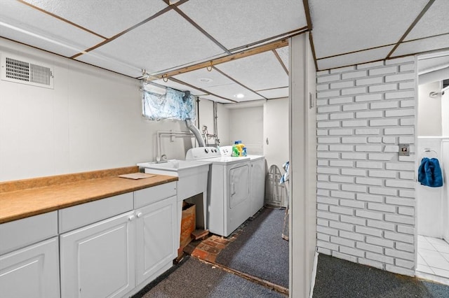 laundry area featuring washing machine and clothes dryer, cabinet space, and visible vents