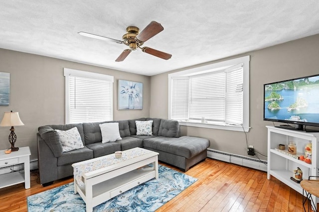 living room with hardwood / wood-style flooring, a ceiling fan, and baseboard heating