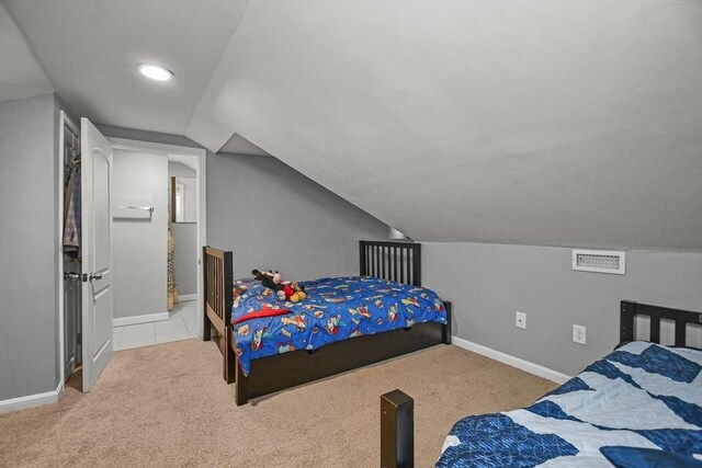 bedroom featuring light carpet and vaulted ceiling