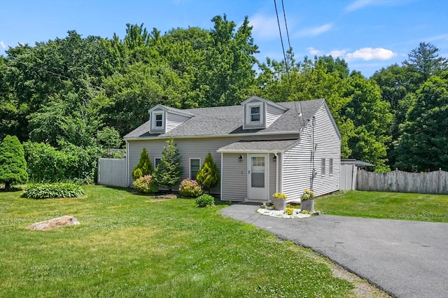 cape cod house featuring a front yard