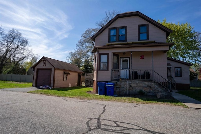 9 Warren St, Dartmouth, MA 02748 - view of front of home with an outdoor structure, a front lawn, aphalt driveway, covered porch, and a detached garage