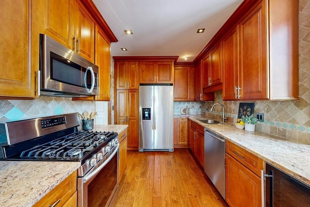 33 Pond Ave Unit Ph1207, Brookline, MA 02445 - kitchen featuring stainless steel appliances, a sink, light wood-style floors, light stone countertops, and wine cooler