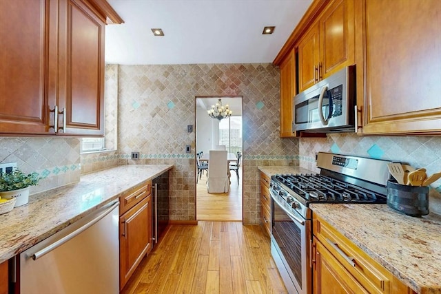 33 Pond Ave Unit Ph1207, Brookline, MA 02445 - kitchen with stainless steel appliances, light wood finished floors, beverage cooler, light stone countertops, and a chandelier