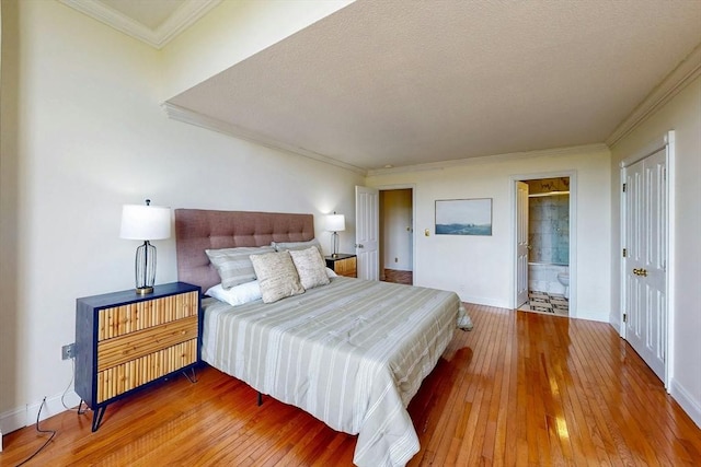 33 Pond Ave Unit Ph1207, Brookline, MA 02445 - bedroom with crown molding, hardwood / wood-style flooring, baseboards, a textured ceiling, and connected bathroom