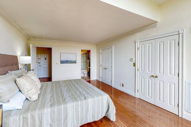33 Pond Ave Unit Ph1207, Brookline, MA 02445 - bedroom featuring hardwood / wood-style flooring, crown molding, two closets, baseboards, and ensuite bath