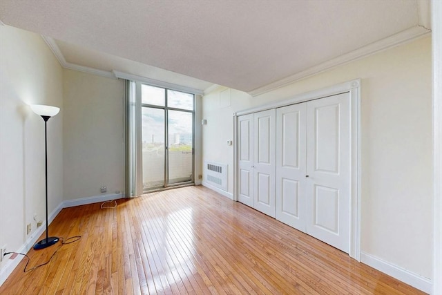 33 Pond Ave Unit Ph1207, Brookline, MA 02445 - unfurnished bedroom featuring light wood-style flooring, access to outside, baseboards, ornamental molding, and a wall of windows