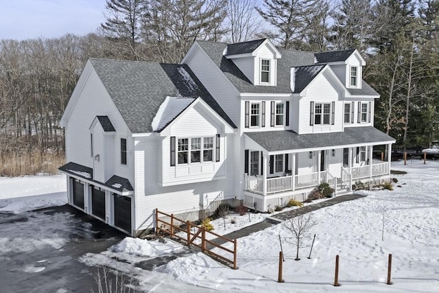 view of front of house with a garage, covered porch, roof with shingles, and aphalt driveway