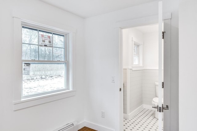 bathroom with tile walls, toilet, and a baseboard radiator