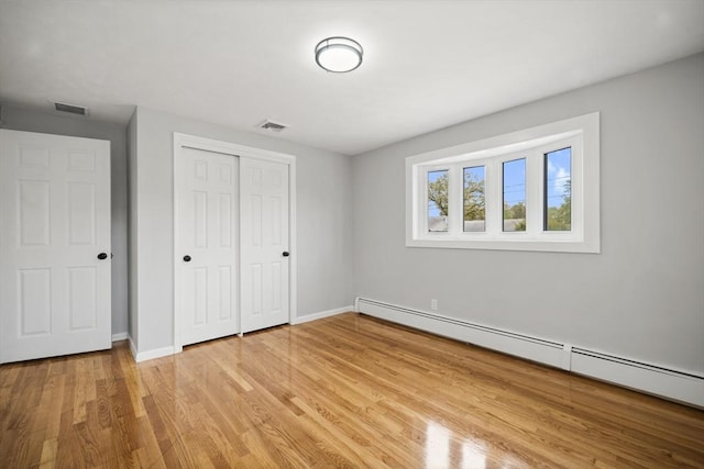 73 Mckinley Ave, Ludlow, MA 01056 - unfurnished bedroom featuring visible vents, baseboards, baseboard heating, and light wood-type flooring