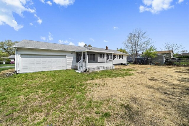 73 Mckinley Ave, Ludlow, MA 01056 - back of property featuring a sunroom, an attached garage, a lawn, and fence