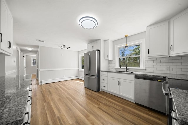 73 Mckinley Ave, Ludlow, MA 01056 - kitchen with visible vents, a baseboard radiator, tasteful backsplash, a sink, and stainless steel appliances