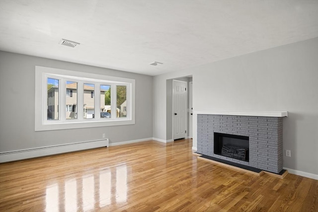 73 Mckinley Ave, Ludlow, MA 01056 - unfurnished living room featuring a fireplace, baseboards, wood finished floors, a baseboard radiator, and visible vents