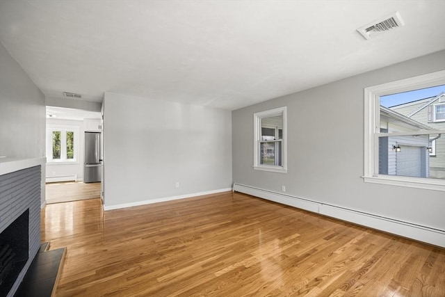 73 Mckinley Ave, Ludlow, MA 01056 - unfurnished living room with visible vents, baseboard heating, and light wood-style floors