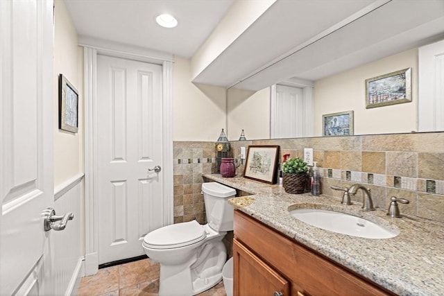 bathroom with vanity, tile patterned floors, toilet, and tile walls