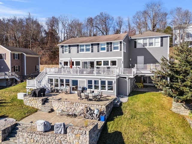 back of house featuring a lawn, a patio, and a deck