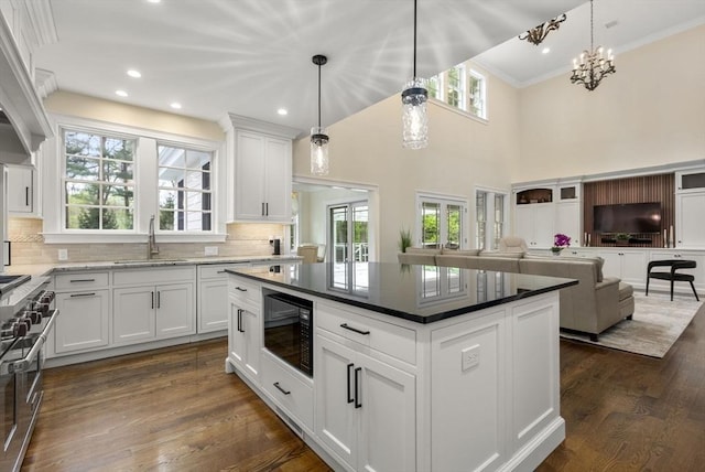 kitchen featuring white cabinetry, sink, black microwave, and a kitchen island