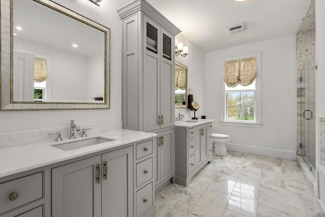 bathroom with vanity, toilet, and a shower with shower door