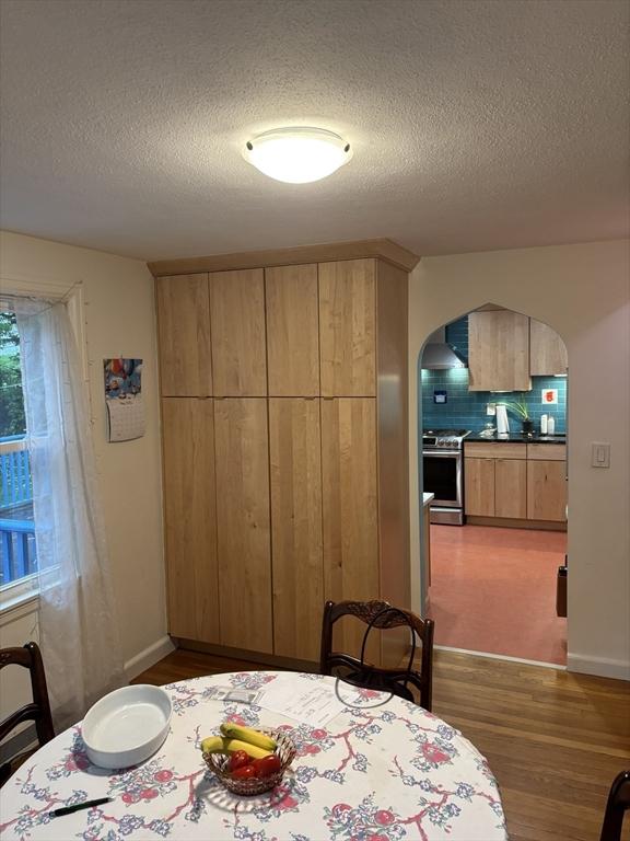 14 Anderson Ave, Holyoke, MA 01040 - dining area featuring arched walkways, wood finished floors, and a textured ceiling