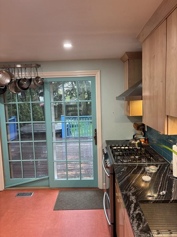 14 Anderson Ave, Holyoke, MA 01040 - kitchen with under cabinet range hood, gas range, decorative backsplash, light brown cabinets, and recessed lighting