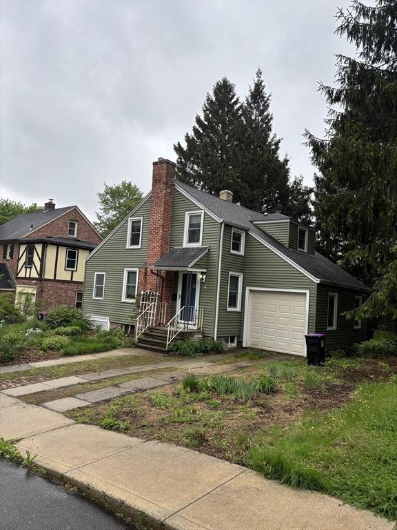 14 Anderson Ave, Holyoke, MA 01040 - view of front of home featuring concrete driveway, an attached garage, and a chimney
