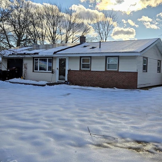 single story home featuring brick siding and a chimney