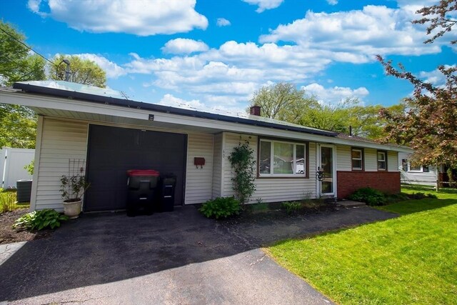 single story home featuring a front yard, an attached garage, and asphalt driveway
